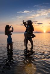Joyful fellows posing and taking photos in water