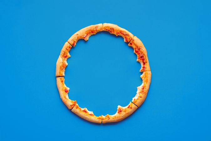 Pizza crust leftovers top view on a blue background