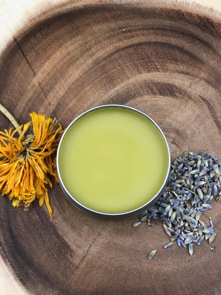 Pot of cannabis salve with lavender and a flower