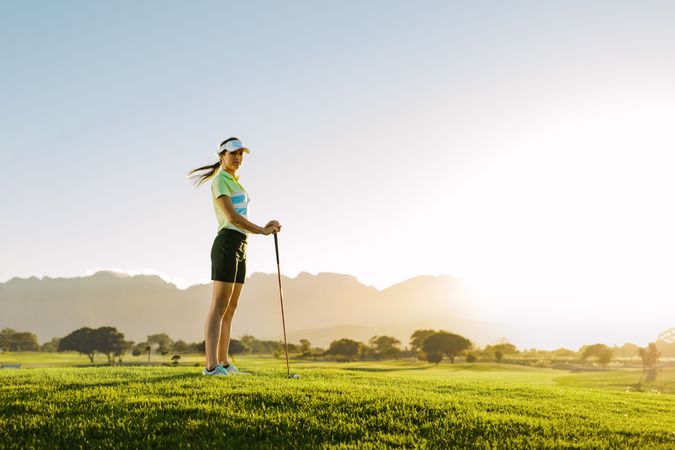 Woman playing golf on field on a sunny day