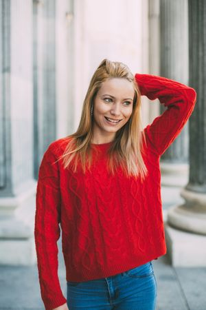 Stylish female standing near marble columns
