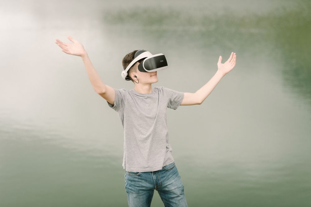 Young teenager with virtual reality glasses outdoors