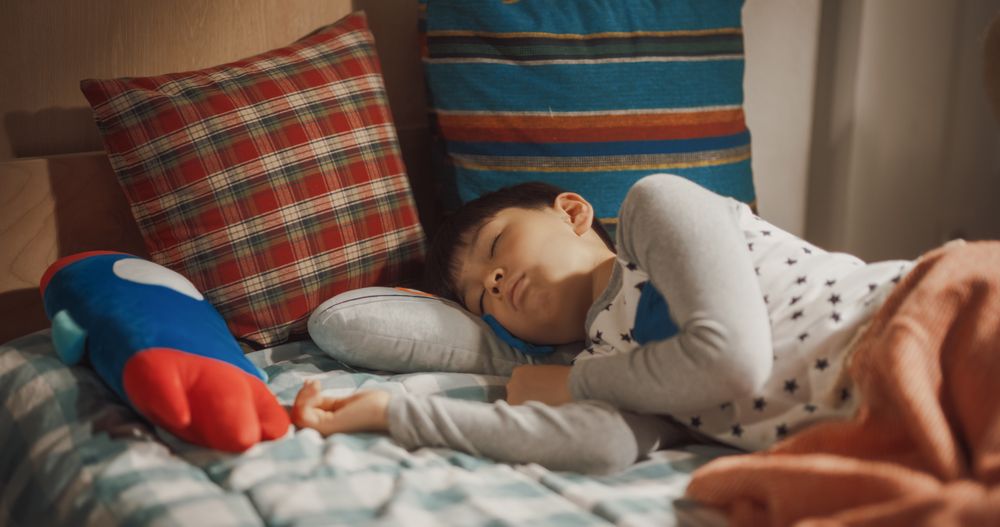 Portrait of Adorable South Korean Boy Waking up in His Bed in Beautiful Sunny Children's Room.