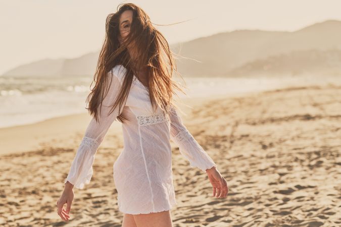 Young woman at the beach at sunset