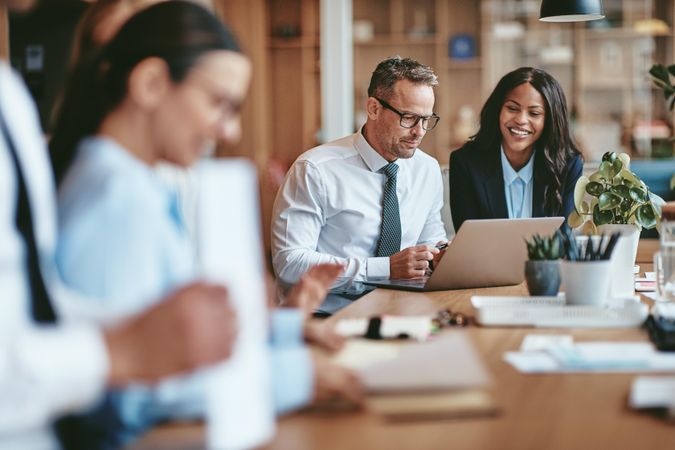 Group of people working on a long desk in an open office