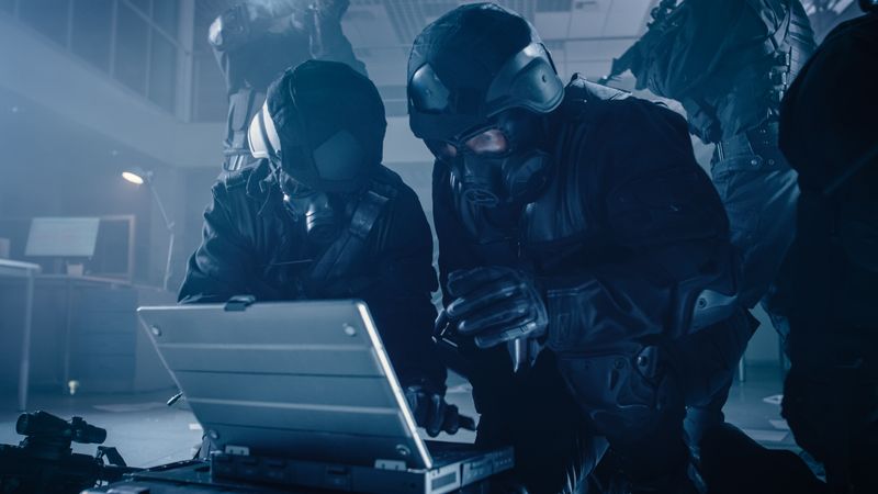 Masked Team of Armed SWAT Police Officers with Rifles are in Dark Seized Office Building with Desks and Computers.