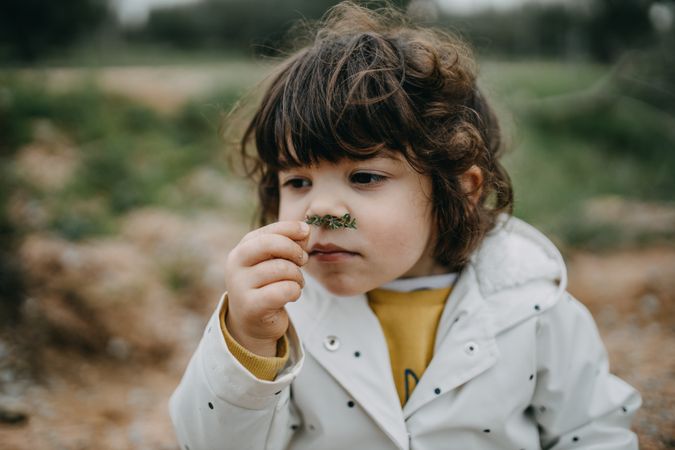 Young girl holding a plant to her nose