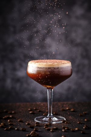 Fresh espresso martini cocktail on table with coffee beans