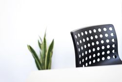 Desk with plant and dark chair