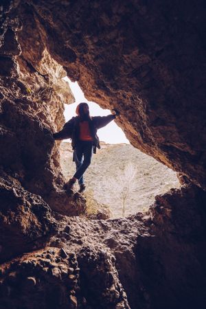 Relaxed tourist woman entering mountain cave
