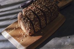 Sliced wholegrain bread on wooden cutting board