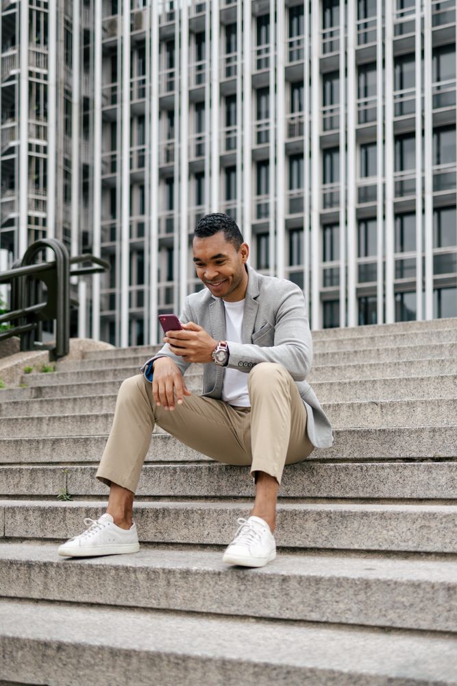 Man sitting on stairs using smartphone