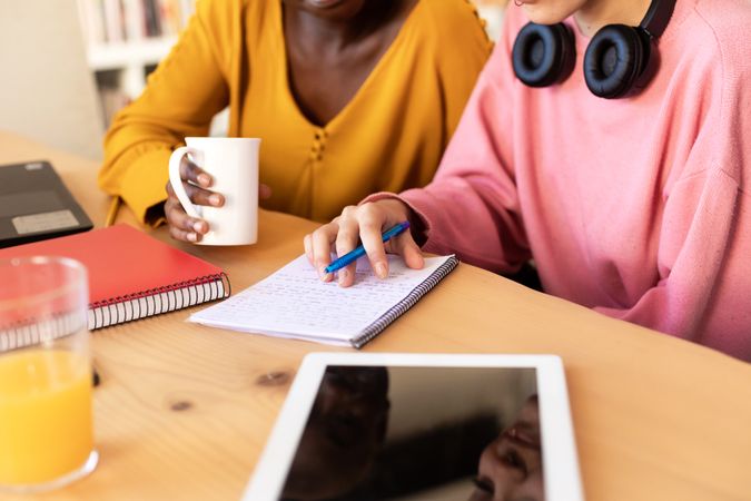 Two women with notepad at table