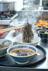 Chef preparing Japanese noodle soup for orders in restaurant