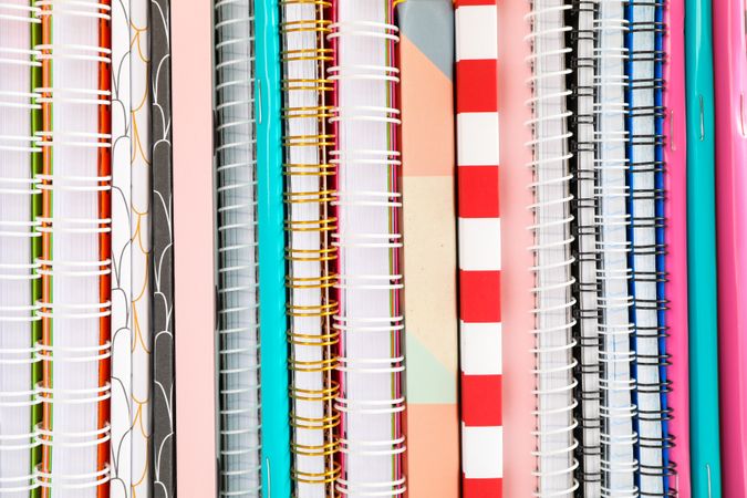 Stack of colorful books and copybooks as background, closeup