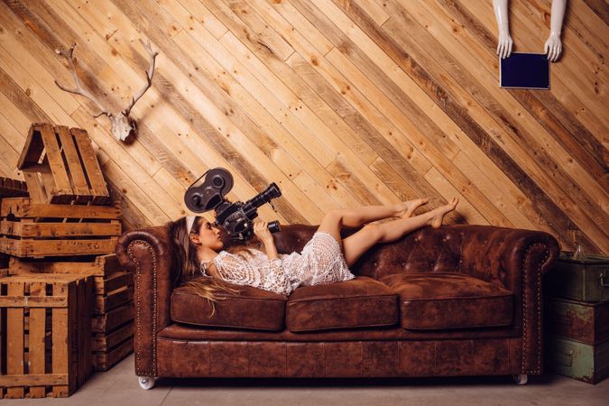 Young woman recording video with a vintage camera