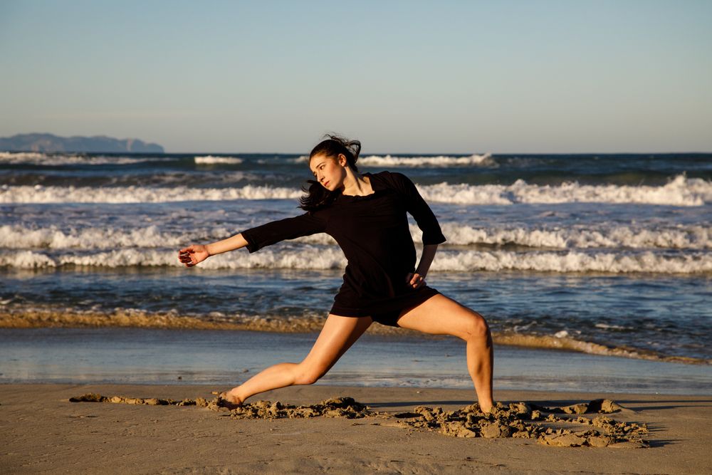 Woman with dancing near water on shore
