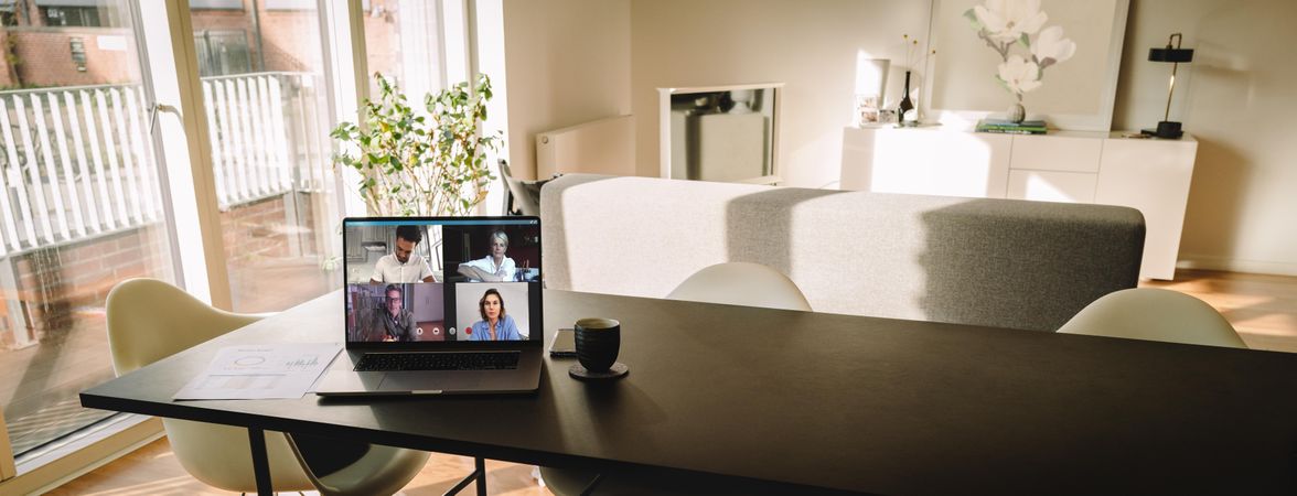 Laptop on table with a video call on the screen in living room