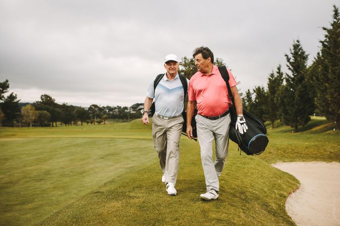Retired golf players walking together on the golf course