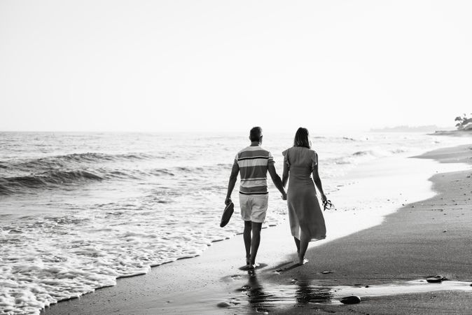 Adult couple walking towards sea