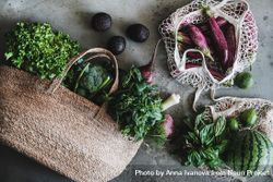 Overhead shot of full grocery shopping jute and mesh bags with fresh produce 0K38N0