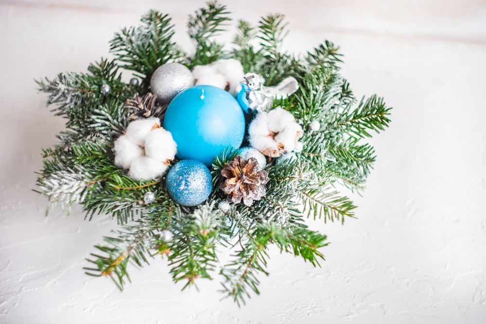 Christmas wreath with blue baubles and pines on table