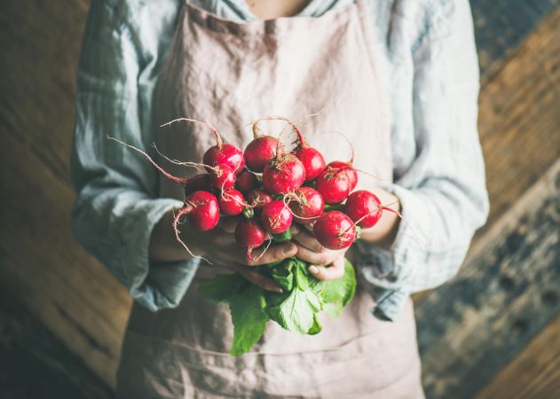 Woman holding bunch of root vegetables in her hands