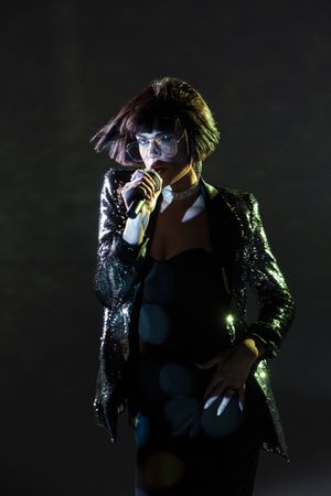 Stylish woman singing on stage