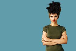 Studio shoot of contemplative Black woman with arms crossed