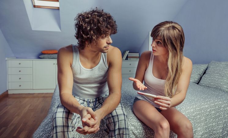 Young couple with pregnancy test having a discussion