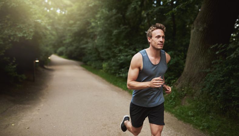 Athletic man in sportswear going for a run in a park