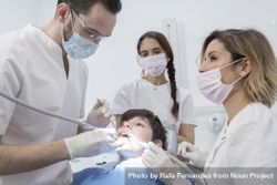 A portrait of a dentist with his team working in the background 42aly5