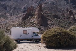 Camper on road against rocky mountains