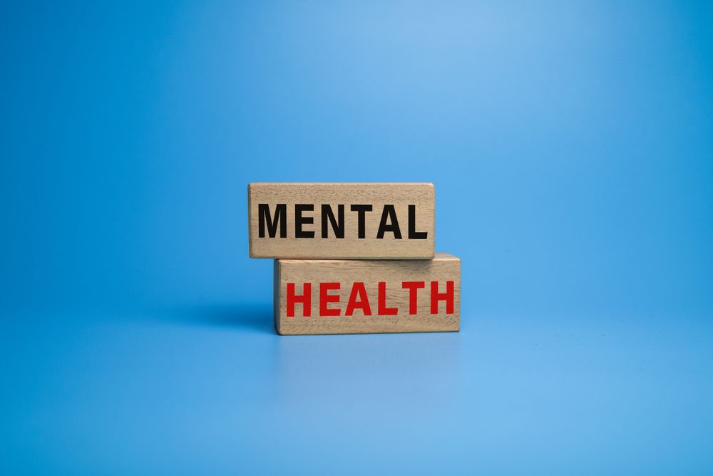 mental health words symbol on wooden blocks on blue background