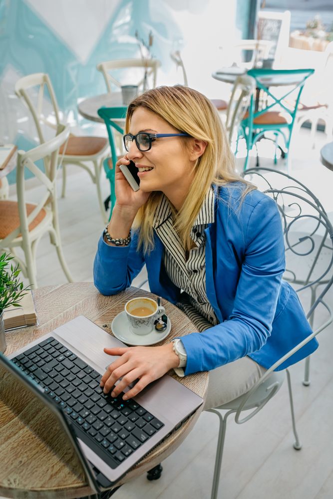 Woman talking on phone with laptop