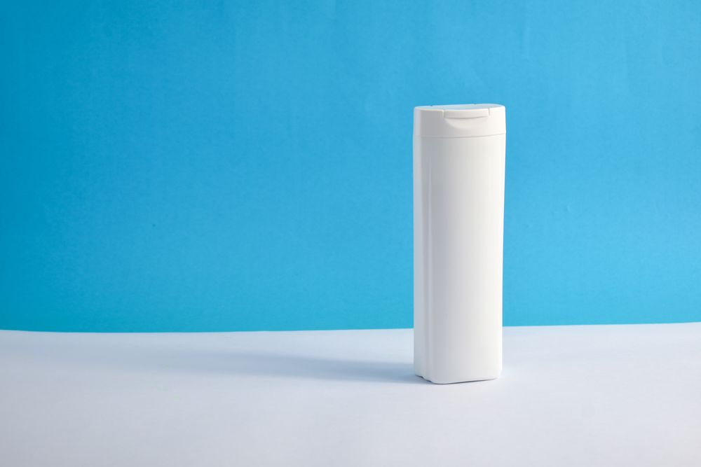 Shampoo bottle with no labels with blue background