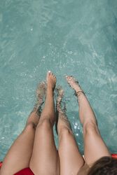 Crop two women sitting on poolside