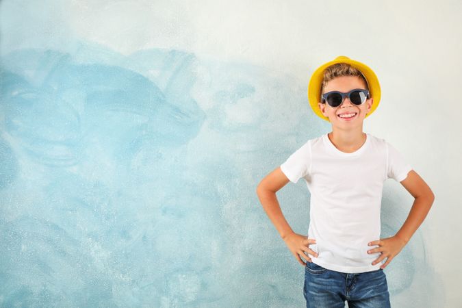 Boy with sunglasses and hat against color background, space for text
