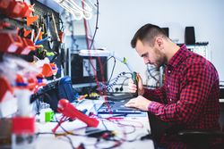 Man repairing laptop at workplace