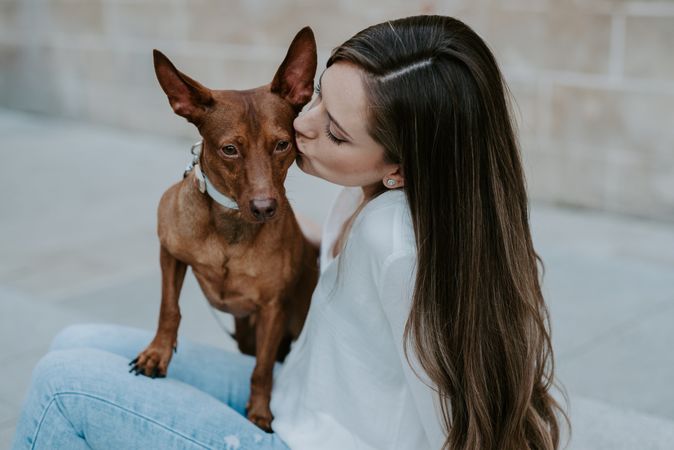 Woman with purebred dog on stone porch