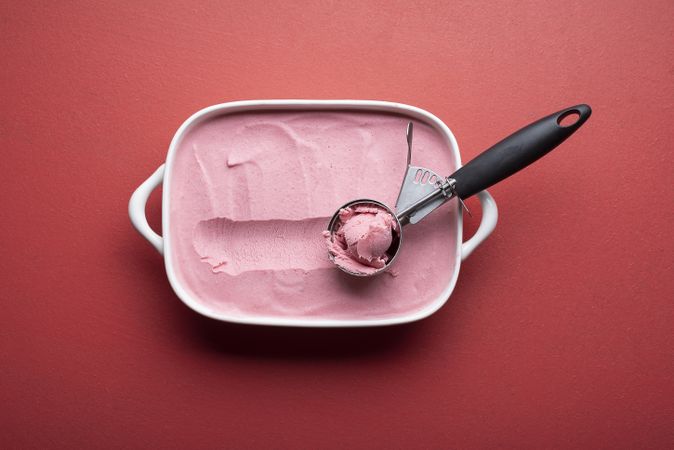 Ice cream tray and scoop on red table
