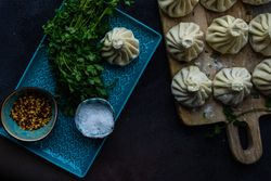 Raw traditional Georgian khinkali dish on wooden board