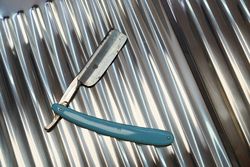 Vintage dangerous razor for haircuts on metal background
