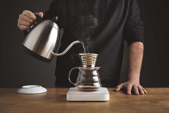 Man making coffee with kettle and pour over device