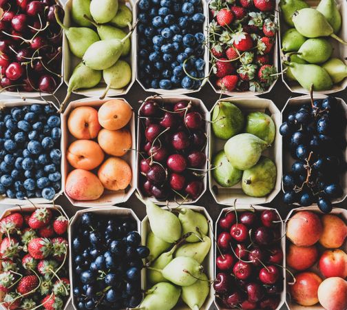 Rows fresh fruit arranged together in eco-friendly boxed