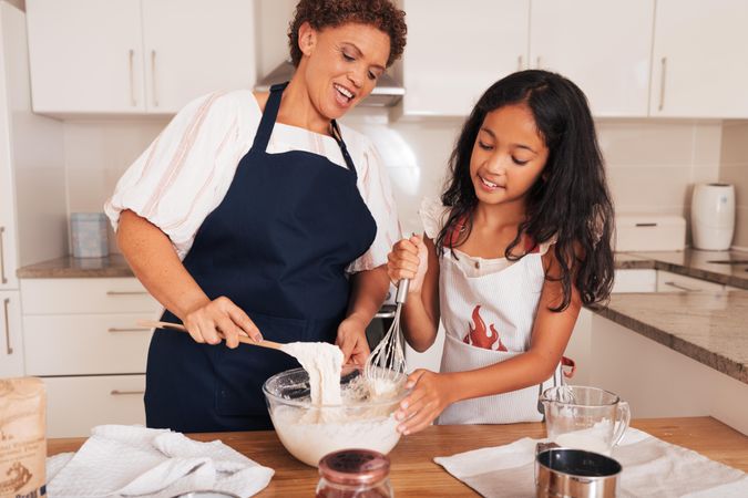 Older woman and child baking in kitchen together