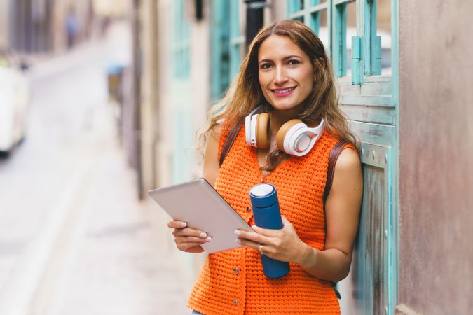 Woman standing on street with tablet