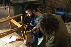 Male artisans creating wooden furniture in workshop