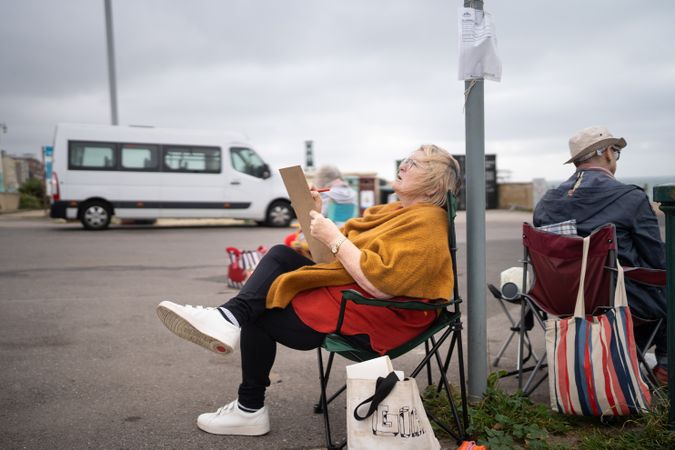 Mature woman sitting calmly outside drawing