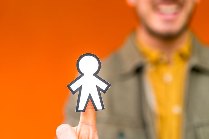 Smiling man holding funny paper toy